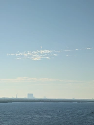just above the clouds, the flare of the rocket as it launches