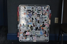 a speed limit sign that has been thoroughly stickerbombed