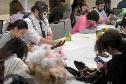 (1/2) people making badges at a dedicated panel