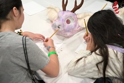 (2/2) people making badges at a dedicated panel